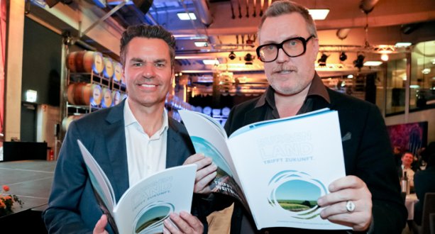 Tourismuschef Didi Tunkel (l.) und Weintourismus-Botschafter Nicholas Ofczarek (r.) blättern im Strategiefolder „Burgenland trifft Zukunft“.